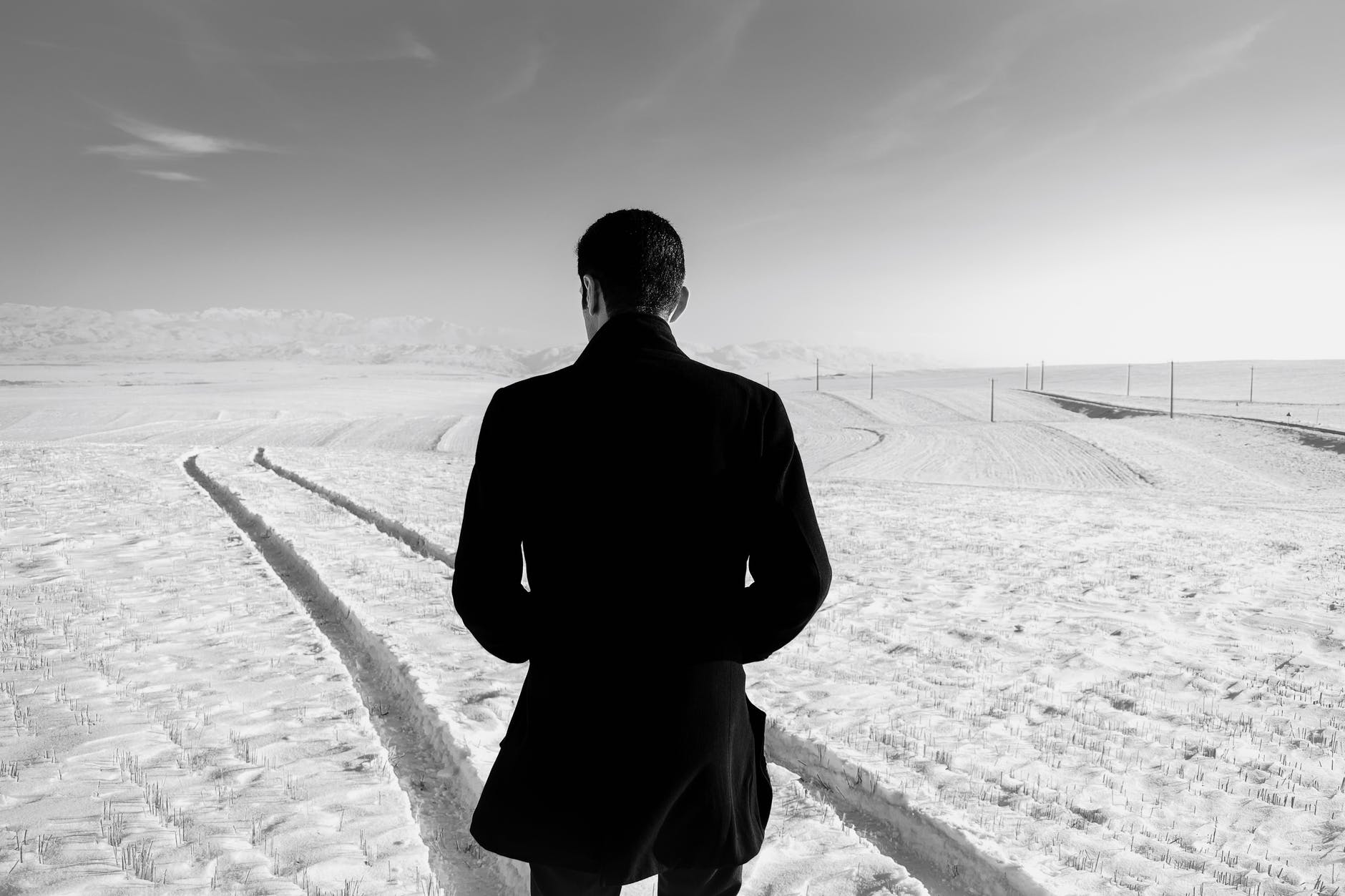 unrecognizable man in snowy field